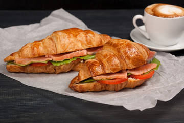 Close up of tasty croissants with salmon lying on the table