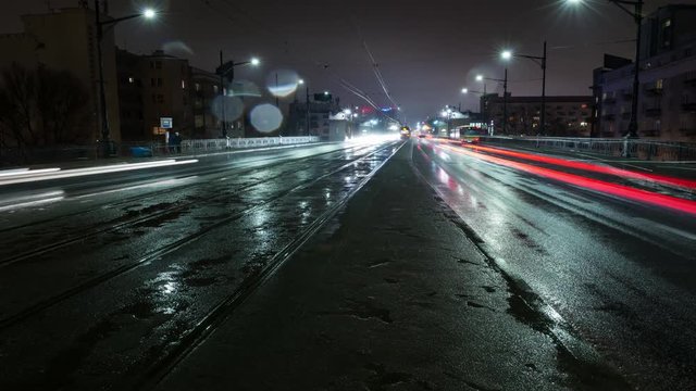 Rainy night time lapse of urban traffic on the street. Long exposure shot, photographed late summer.
