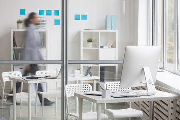 Business workplace by transparent wall and moving businessman behind it