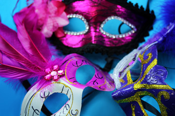 Three bright carnival masks on a blue background close-up © volhavasilevich
