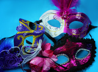 Three bright carnival masks on a blue background close-up