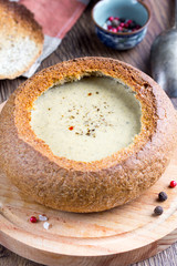 Cream soup of potatoes, vegetables, cheese, mushrooms, serve in bread, rustic style, tasty food