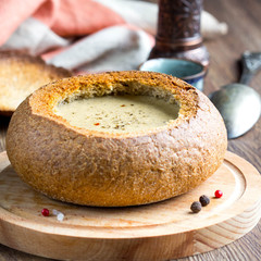 Cream soup of potatoes, vegetables, cheese, mushrooms, serve in bread, rustic style, tasty food
