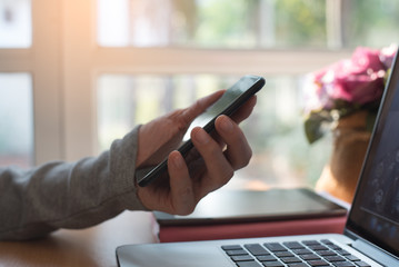 Man holding smart phone and laptop computer