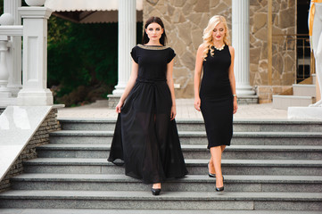 Two beautiful girls going down the outside stairs.