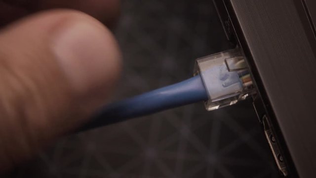 Male hand connects the network cable RG45 to the laptop