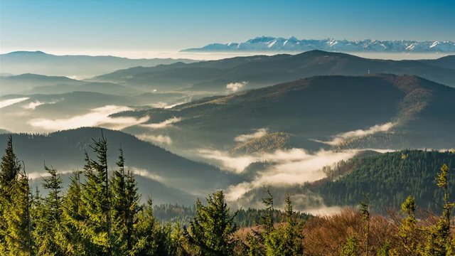 Mists in Carpathian mountains, snowy Tatra in the background, timelapse, Poland landscape