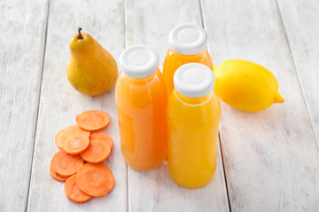 Bottles with fruit and vegetable juices on wooden table