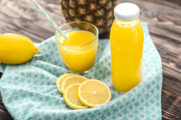 Bottle and glass of freshly squeezed lemon juice on table