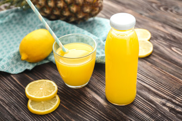 Bottle and glass of freshly squeezed lemon juice on table