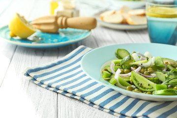 Plate with fresh vegetable salad on table