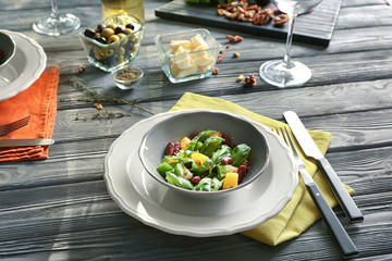 Bowl with fresh vegetable salad on table