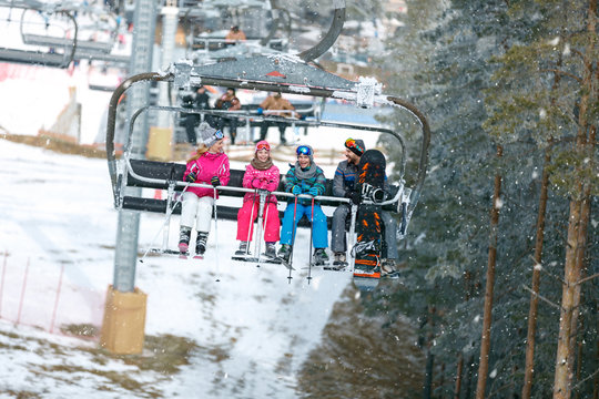 Family with chair lift going on ski terrain