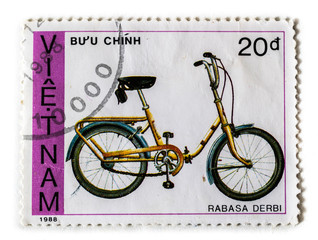 Old postage stamp with yellow bicycle rabasa derbi, printed in Vietnam 1988
