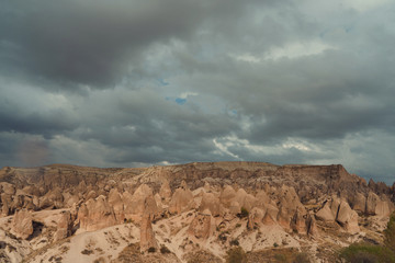 rocky landscape in cloudy weather, rain and sun in canyon