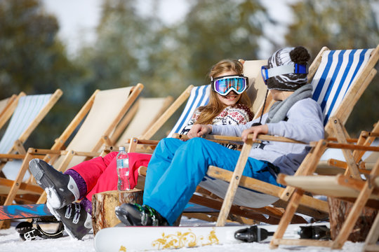 Children enjoys in sun lounger on ski terrain