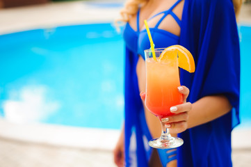 Women drinking cocktail in pool. Portrait of beautiful young women drinking cocktail on the poolside