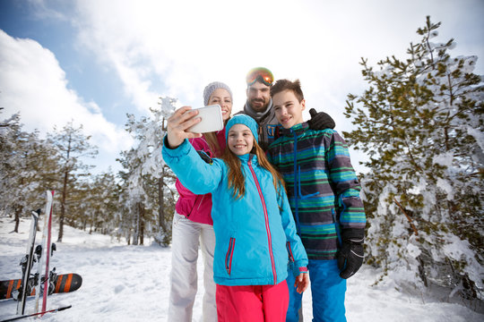 Girl with family taking photo with cell phone