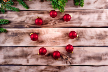 Christmas fir tree on natural wooden background with red balls.