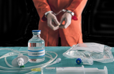 Prisoner handcuffed to death by lethal injection, vial with sodium thiopental and syringe on top of...