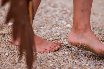 children's feet are walking on the sand