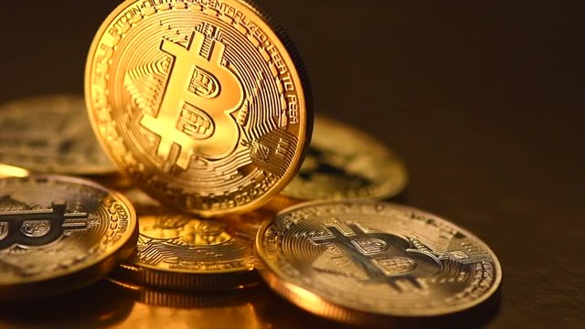 Bitcoin crypto currency. BTC coins on black background. Blockchain technology, Bitcoin mining concept. Rotation 360 degrees. 4K UHD video 3840x2160