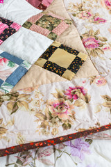 home, vintage, hobby concept. an incredible homemade blanket made from satine performed in a patchwork style with ornament have flower petals, plants and landscapes