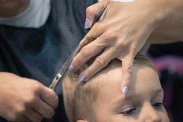 Obraz na płótnie Canvas Close up of boy getting haircut at barber shop.