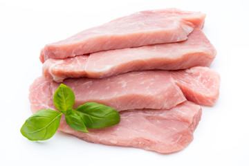 Fresh pork fillet with basil on a white background.