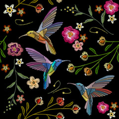 Beautiful hummingbirds and exotic flowers embroidery on black background. Template for clothes, textiles, t-shirt design. Humming bird and tropical flowers embroidery seamless pattern