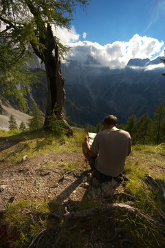 Man studying a map in the mountain landscape, Triglav National Park, Slovenia © Tulda