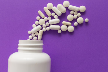 Capsules spilling out of white bottle. Violet background. Line, way course concept.