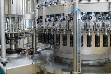 Bottling factory - Black juice bottling line for processing and bottling juice into bottles. Selective focus. 