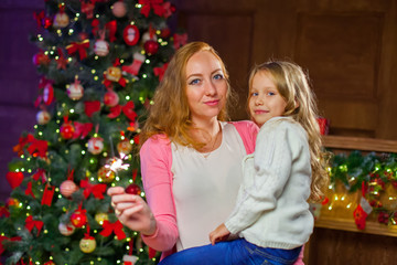 Mom and daughter having fun at a New Year's celebration, holding