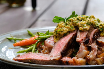 Close up Steak with Green Olive Pesto. (selective focus)