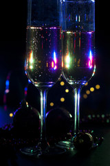 two champagne glasses with christmas lights and decorations