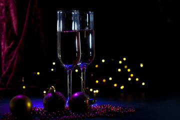 two champagne glasses with christmas lights and decorations