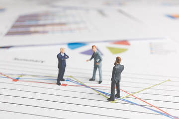 Miniature People : Businessman standing on a Paper graph chart ,Developing a teamwork concept