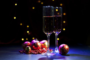 two champagne glasses with christmas lights and decorations. selective focus