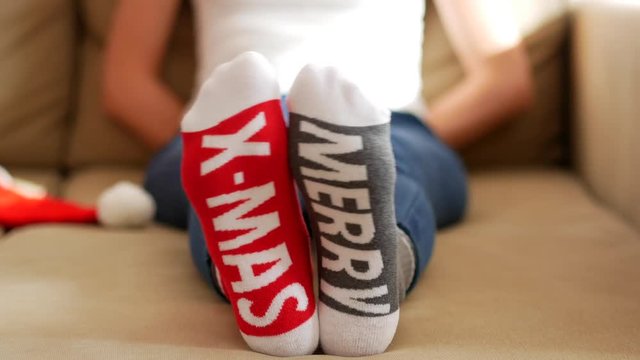 Woman in Christmas socks with "Merry X-Mas" text