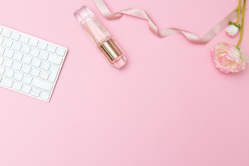 Feminine desk and accessories on a pink background. Copy space