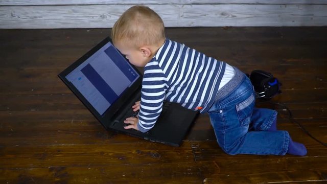 beautiful one year old child is played with a laptop. business comcept