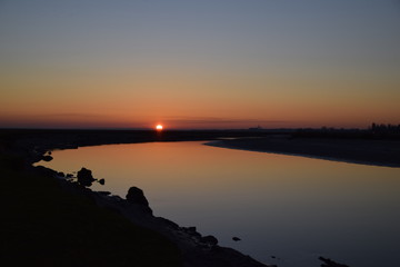 Obraz premium Coucher de soleil sur le fleuve de la Sélune qui se jette dans la baie du Mont Saint Michel