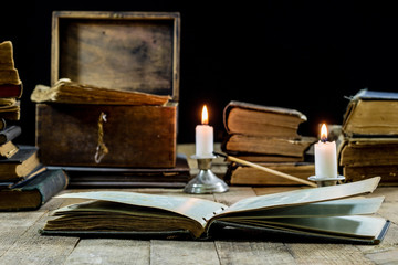 Old books and candles on a wooden table. Old room, reading room.