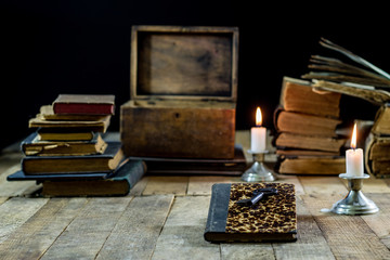 Old books and candles on a wooden table. Old room, reading room.