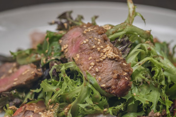 Close up Roasted beef with herbed bread crust sliced and vegetable. (selective focus)