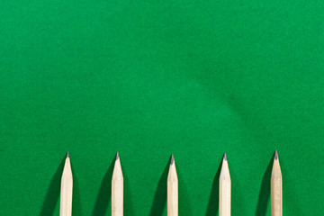 Pencils placed on a green background or green board. Concept about education.