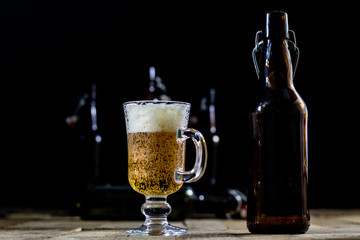 A pint of tasty beer on a wooden table. Beer in pint and beer bottles.