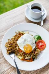 homemade indonesian fried noodle with a cup of coffee