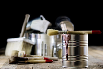 Cans of paint and brush on a wooden table. Painting with brushes.